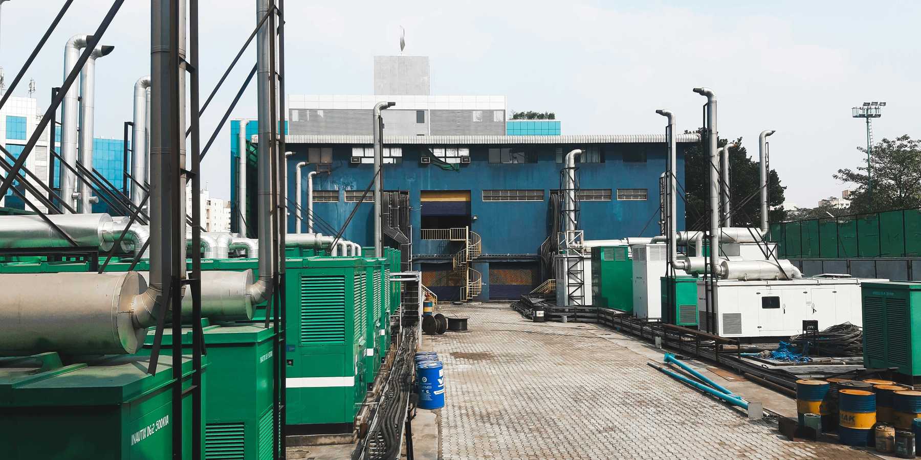 a factory with a lot of green and white generators on platforms outside