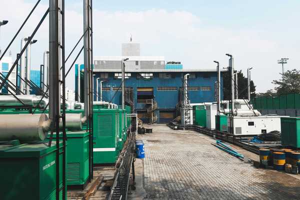 a factory with a lot of green and white generators on platforms outside