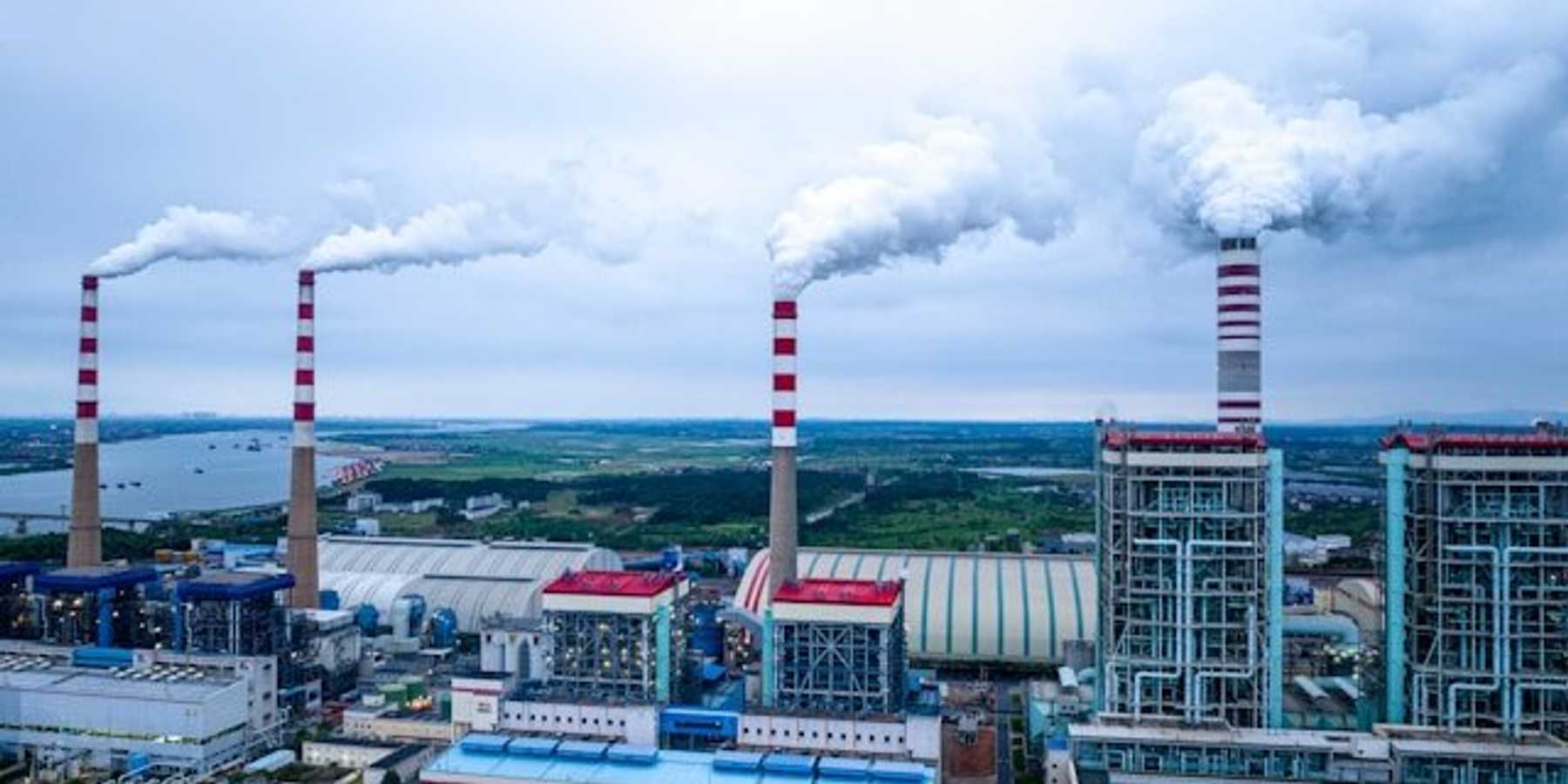 A factory with smoke spewing from smokestacks.