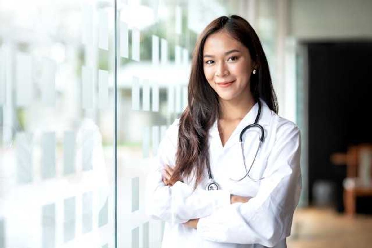 A female doctor standing next to a glass wall
