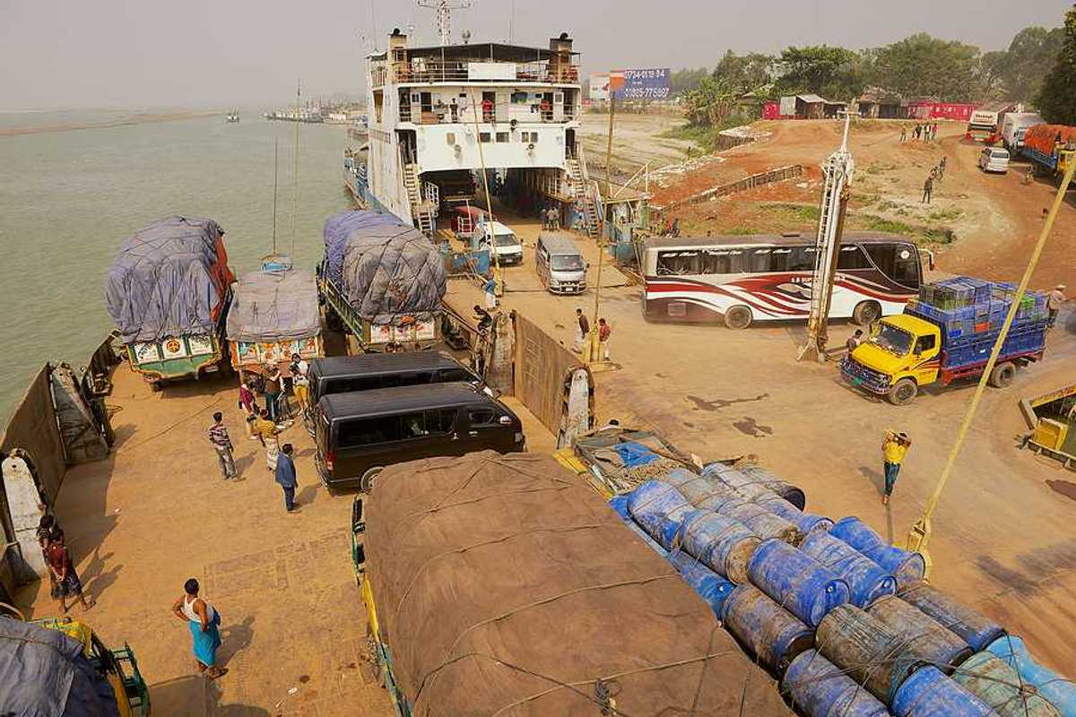 A ferry unloading trucks on the edge of a river in Bangladesh