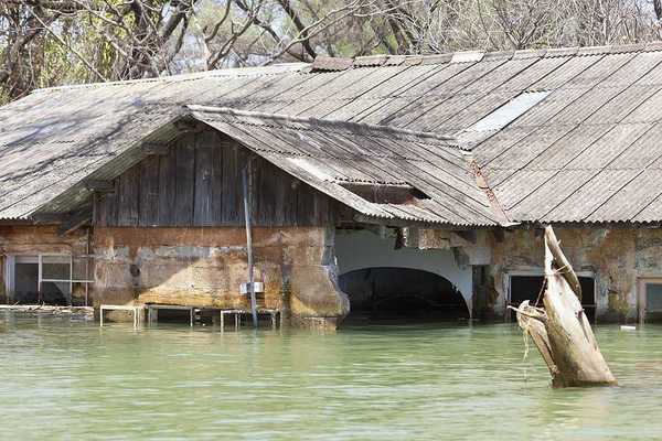 A flooded building with a metal roof
