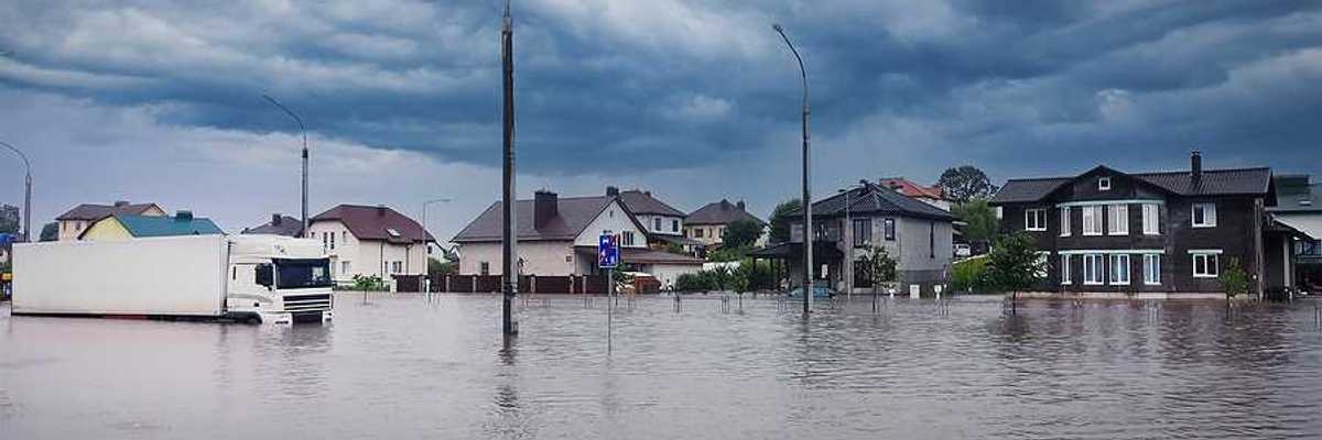 A flooded street with houses in the background