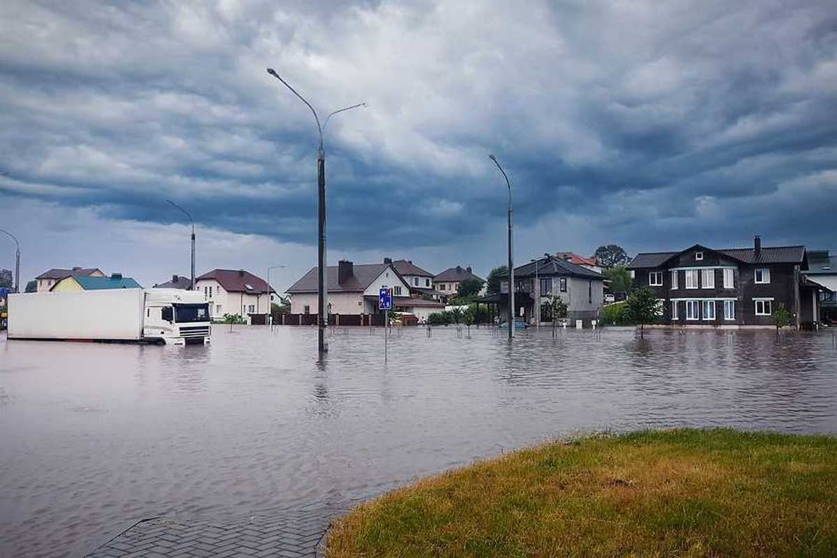 A flooded street with houses in the background