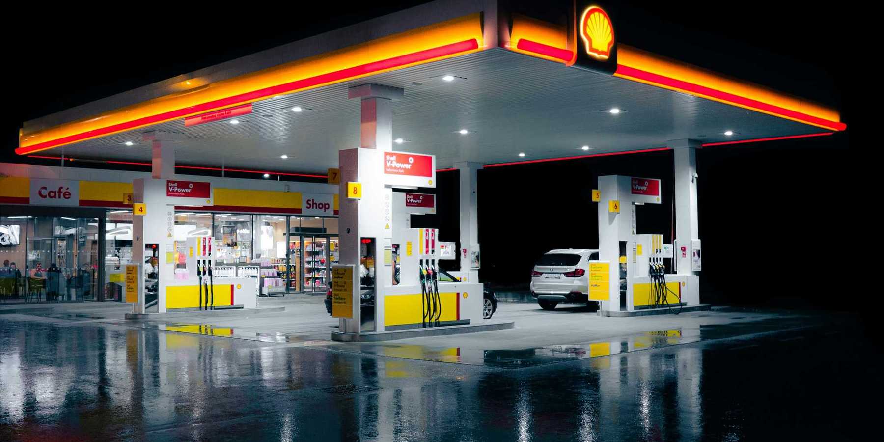 a gas station lit up at night time.