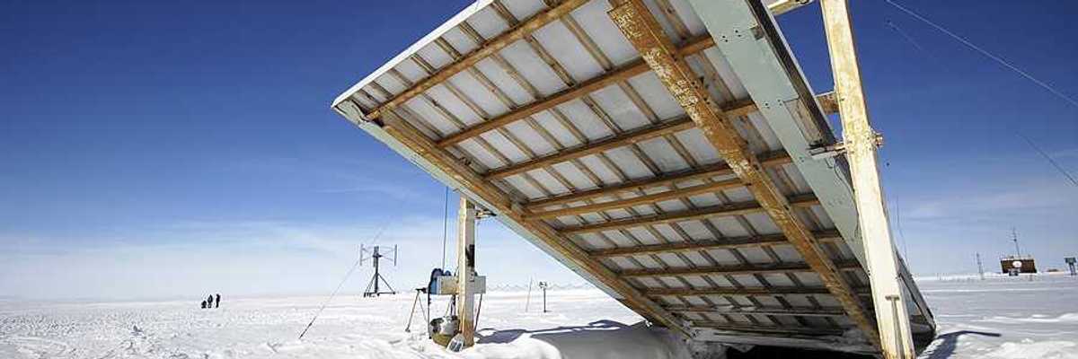 A giant door opening onto an underground research station in a snowy landscape