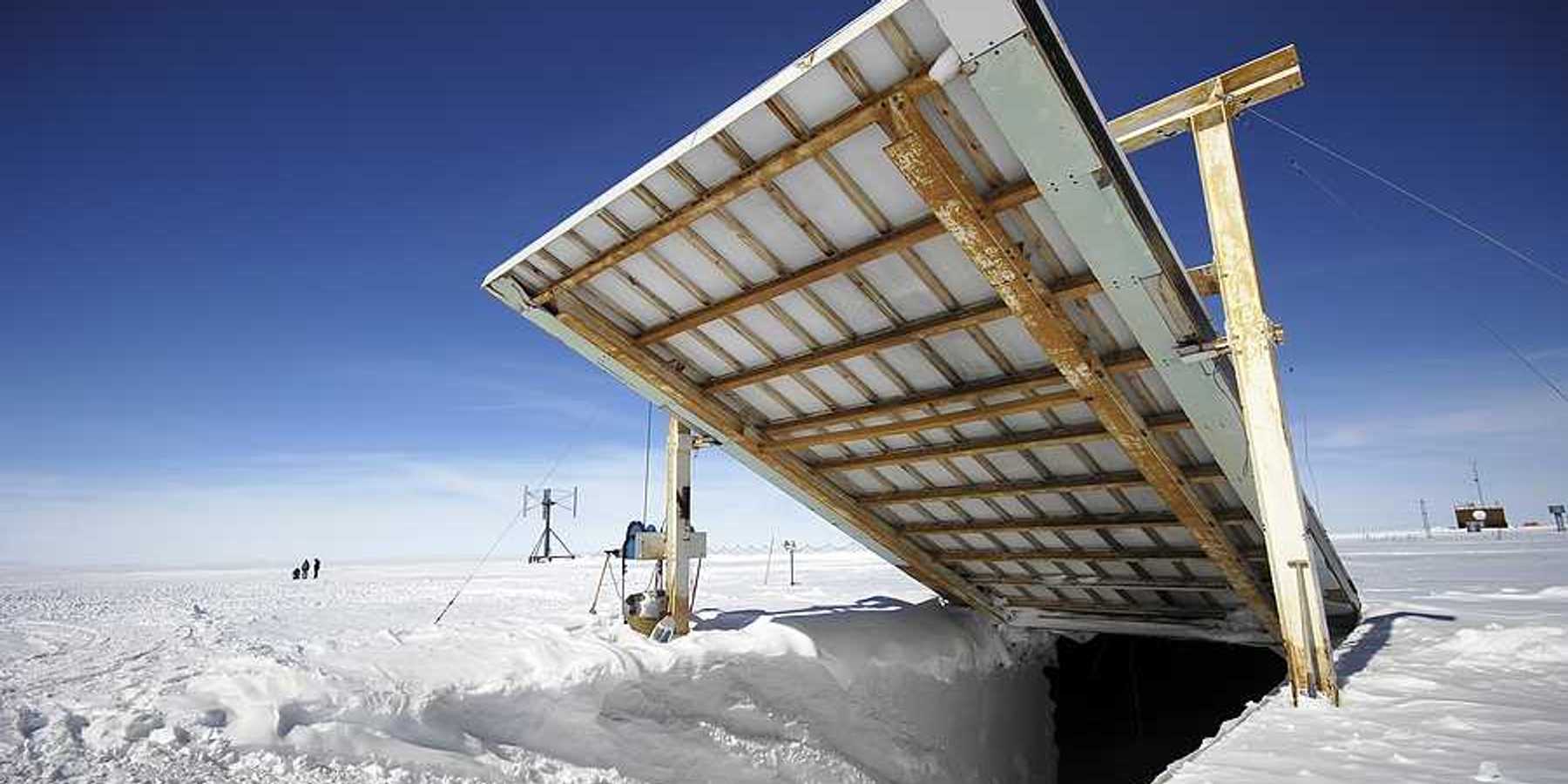 A giant door opening onto an underground research station in a snowy landscape