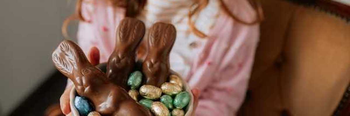 A girl holding a bowl with easter chocolate in it