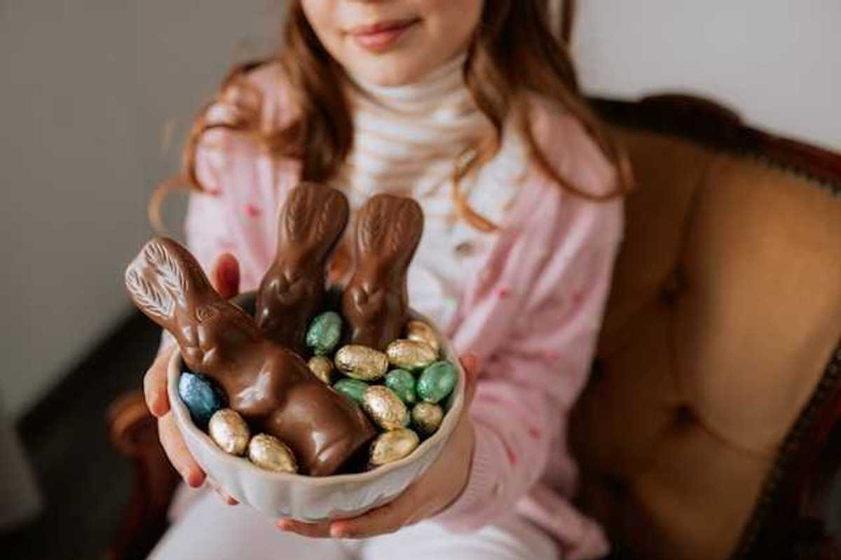 A girl holding a bowl with easter chocolate in it