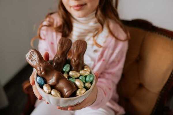 A girl holding a bowl with easter chocolate in it