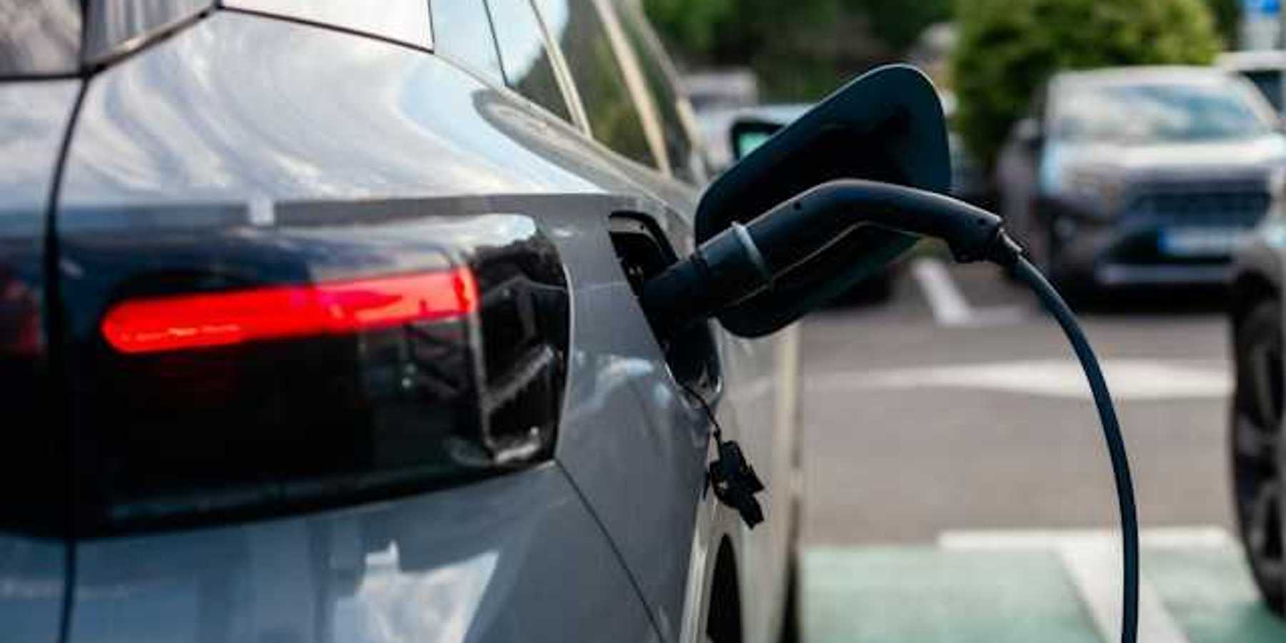 A gray sedan being charged at an electric charging station