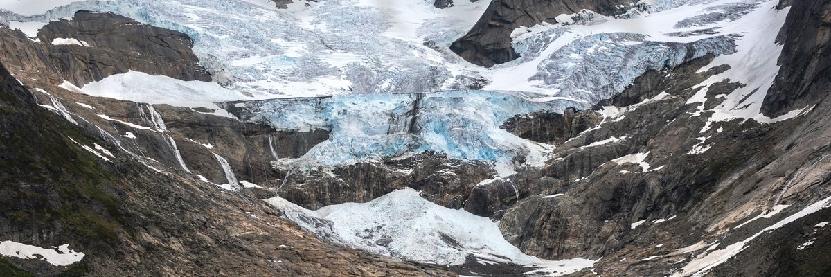 A Greenland glacier receding from a brown and gray valley