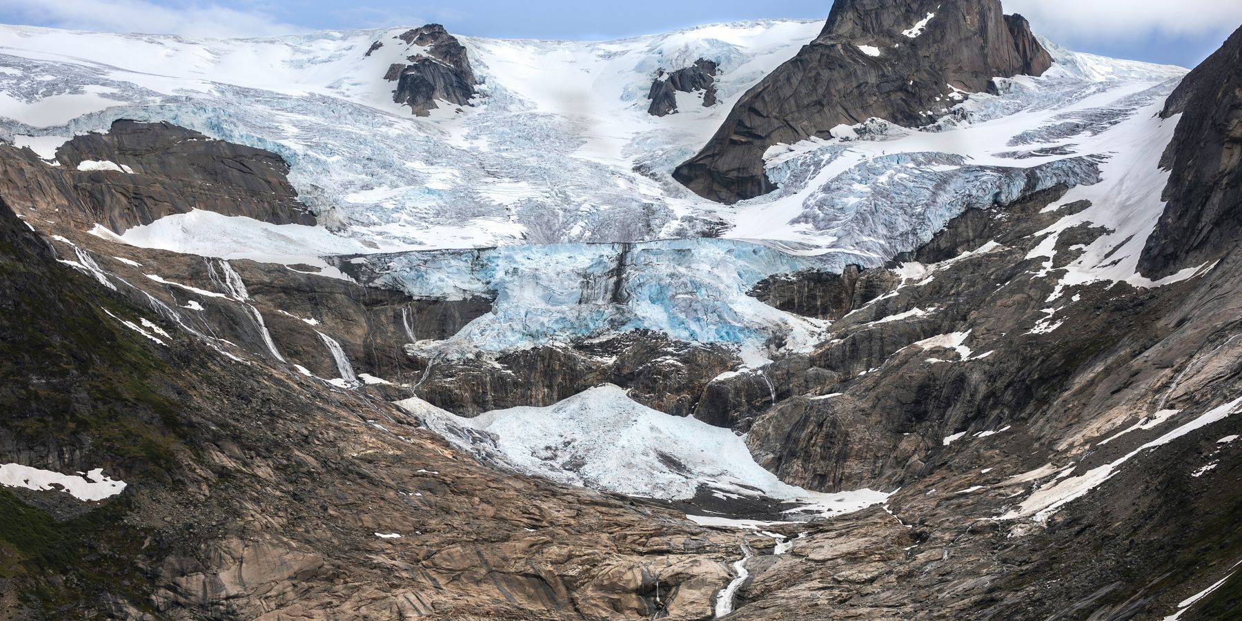A Greenland glacier receding from a brown and gray valley