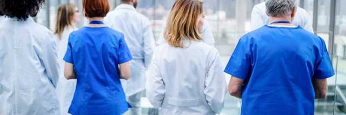 A group of doctors walking down a hallway in a hospital