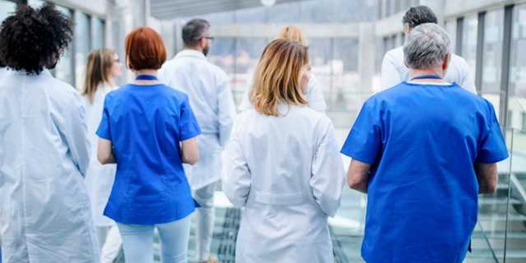 A group of doctors walking down a hallway in a hospital