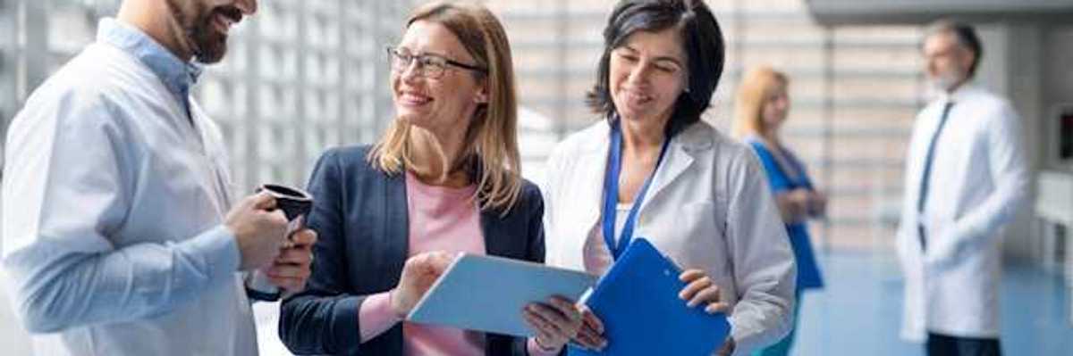 A group of hospital staff and administrators discussing something in a hallway