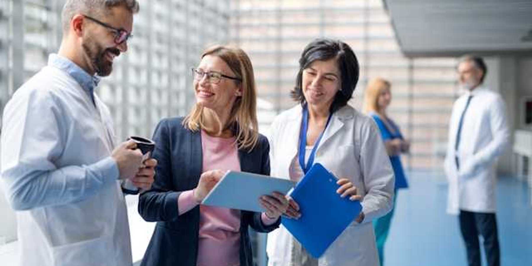 A group of hospital staff and administrators discussing something in a hallway
