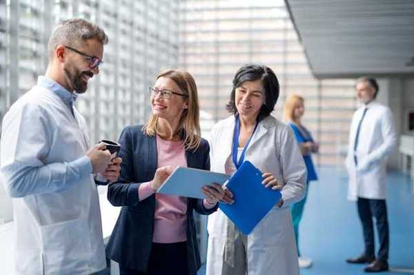 A group of hospital staff and administrators discussing something in a hallway