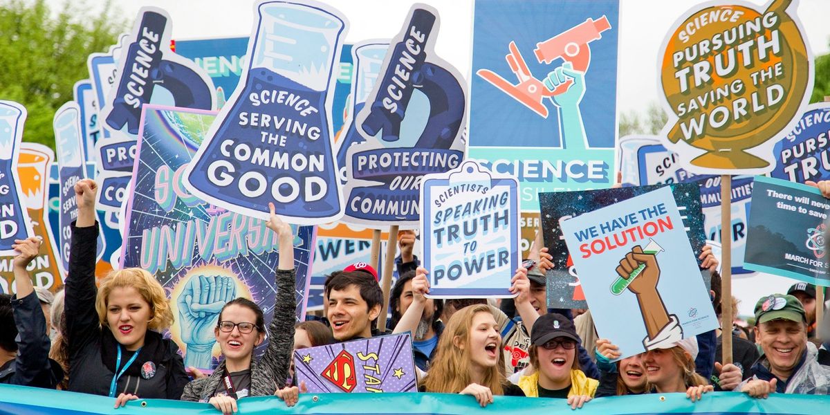 A group of people at a demonstration holding signs in support of science.