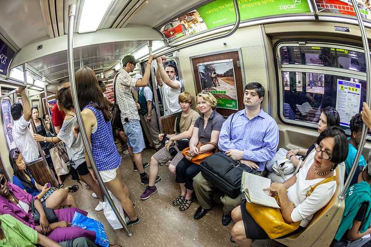 A group of people in a subway car on a hot day