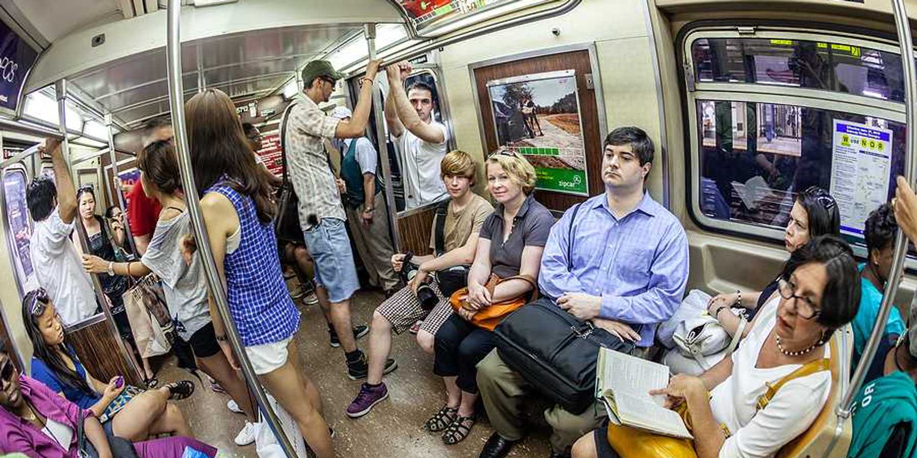 A group of people in a subway car on a hot day