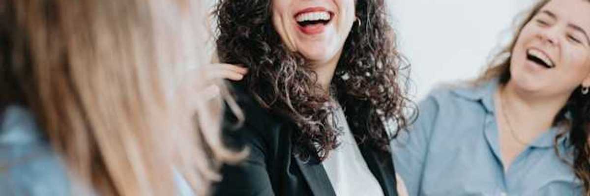 A group of three women laughing together
