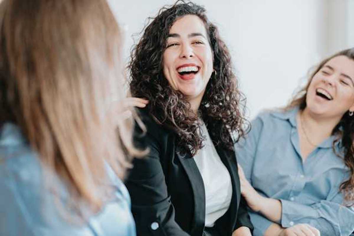 A group of three women laughing together