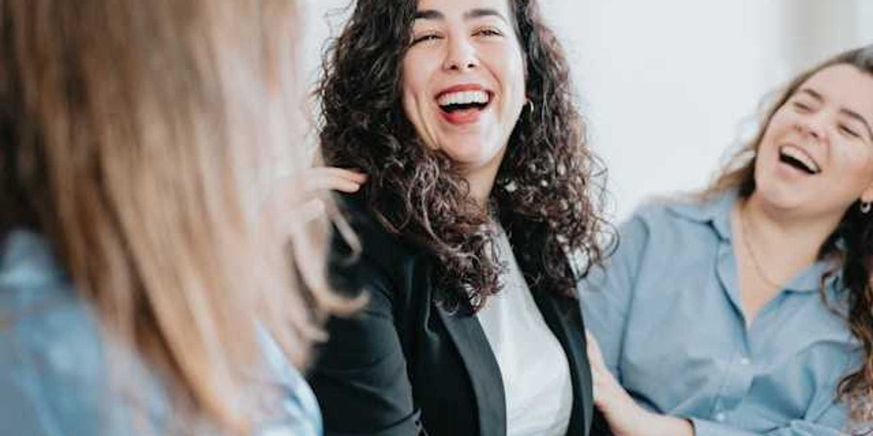 A group of three women laughing together