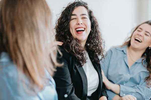 A group of three women laughing together