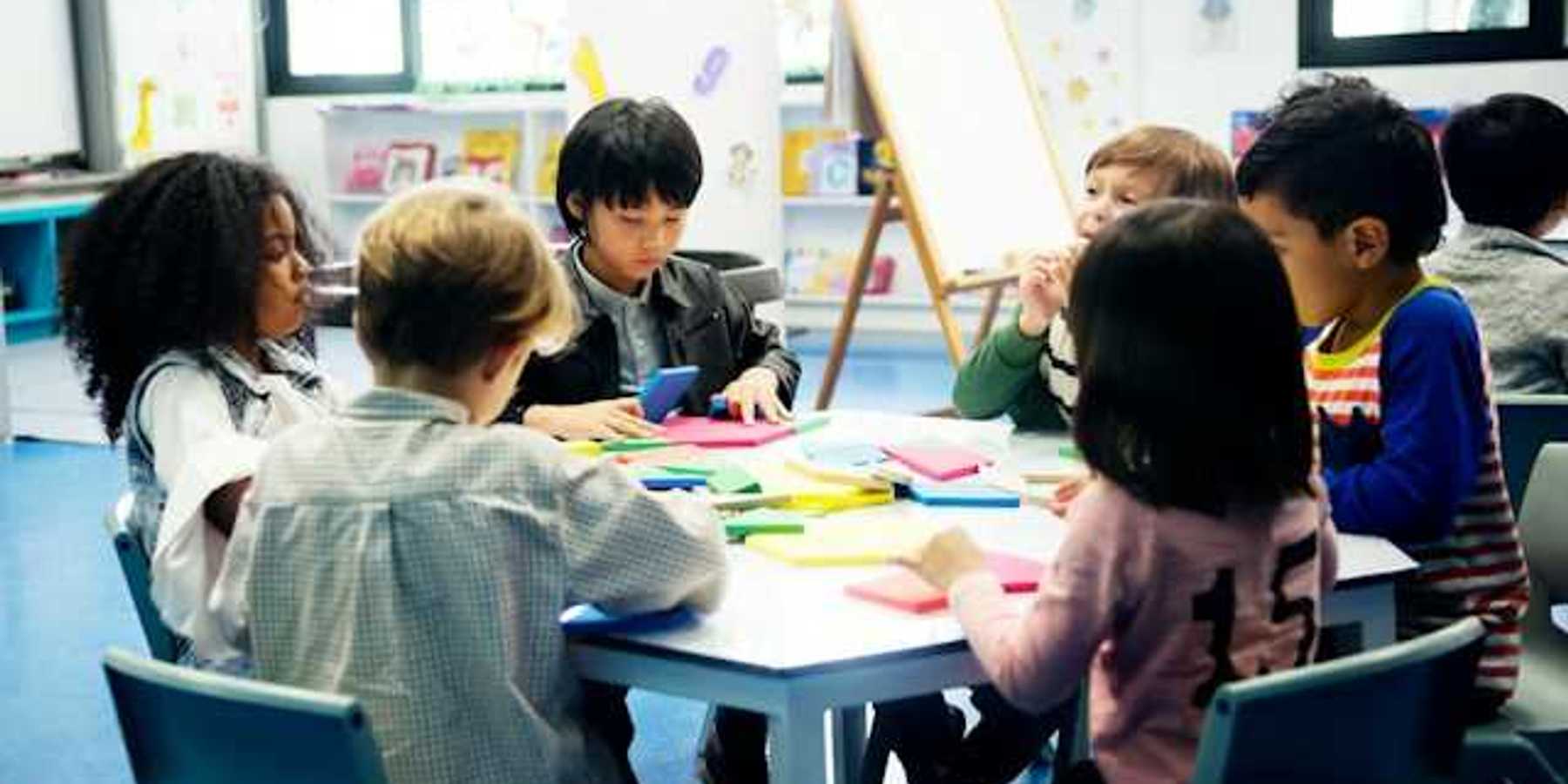 A group of young schoolchildren sitting around a table
