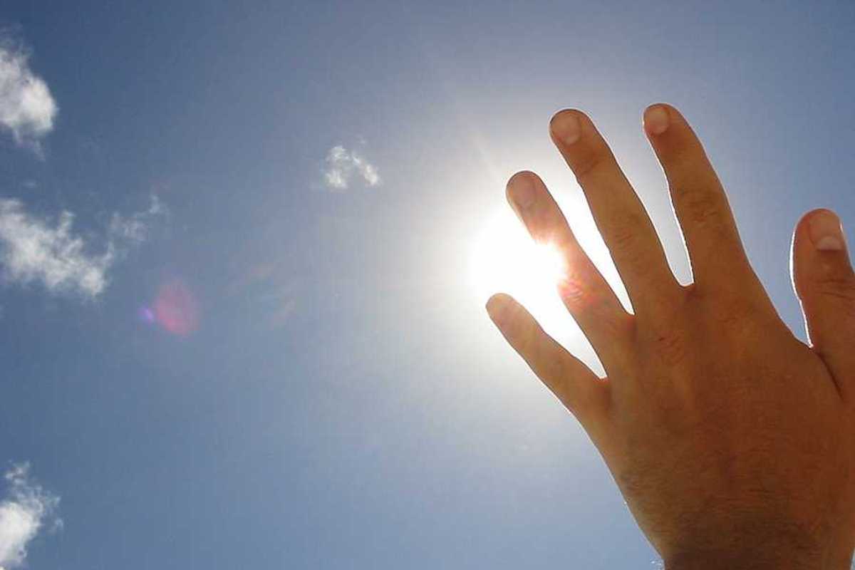 A hand blocking the sun's rays