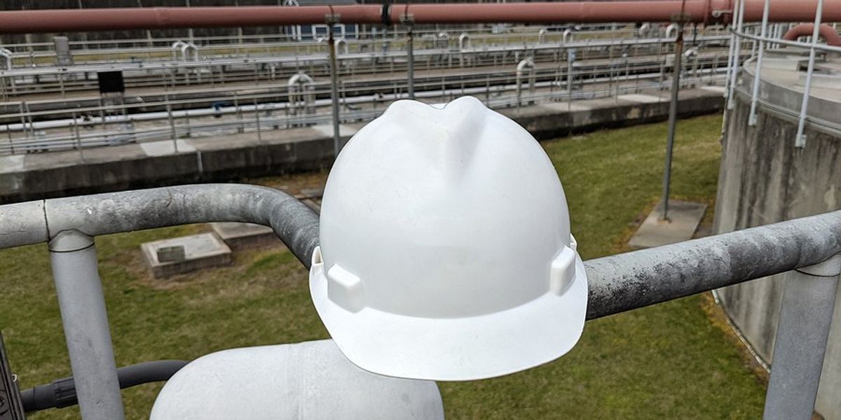 A hard hat balancing on a series of pipes.