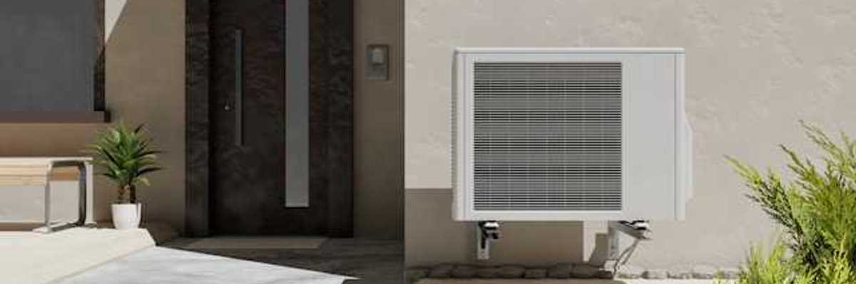 A heat pump attached to a wall outside a home