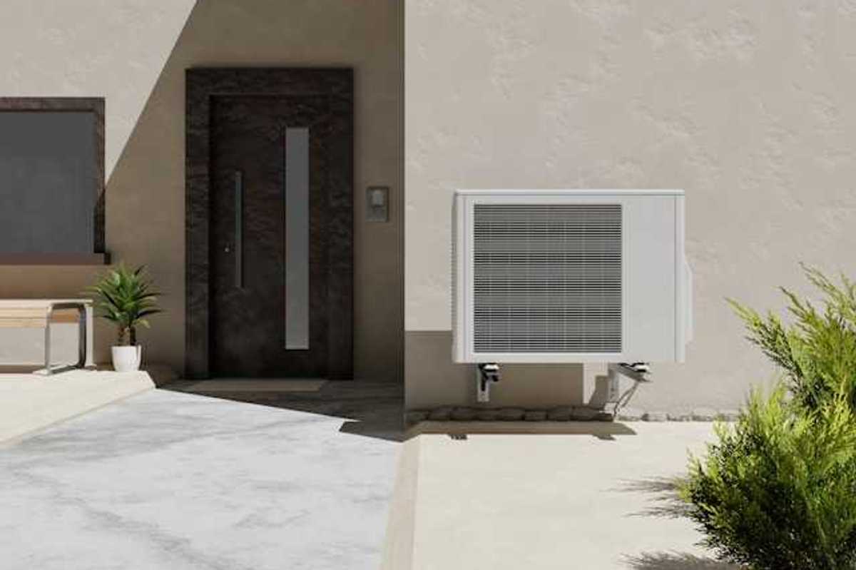 A heat pump attached to a wall outside a home