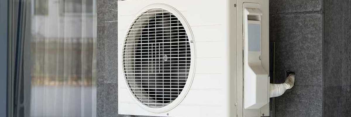 A heat pump attached to the side of a house