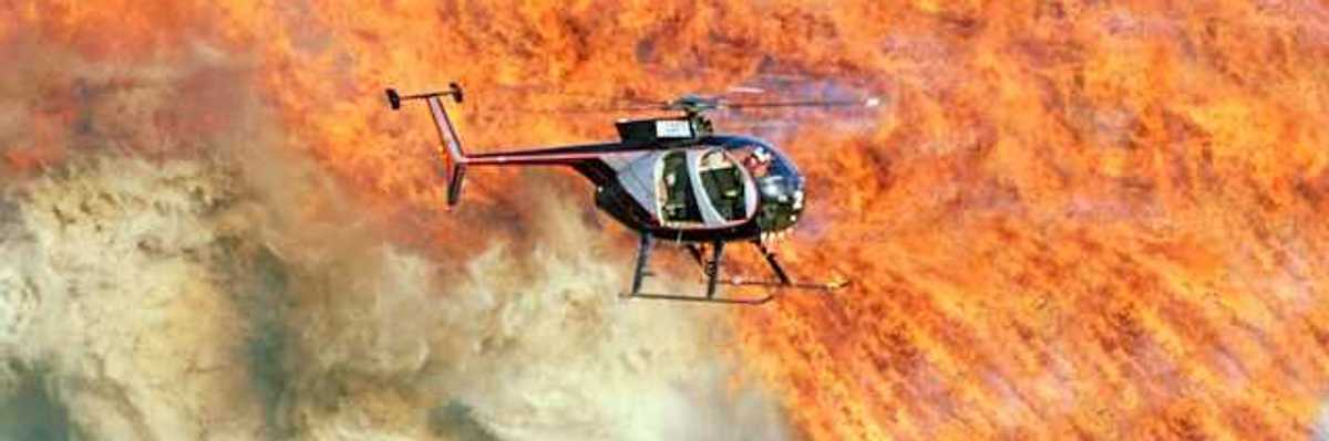 A helicopter flying over a large fire