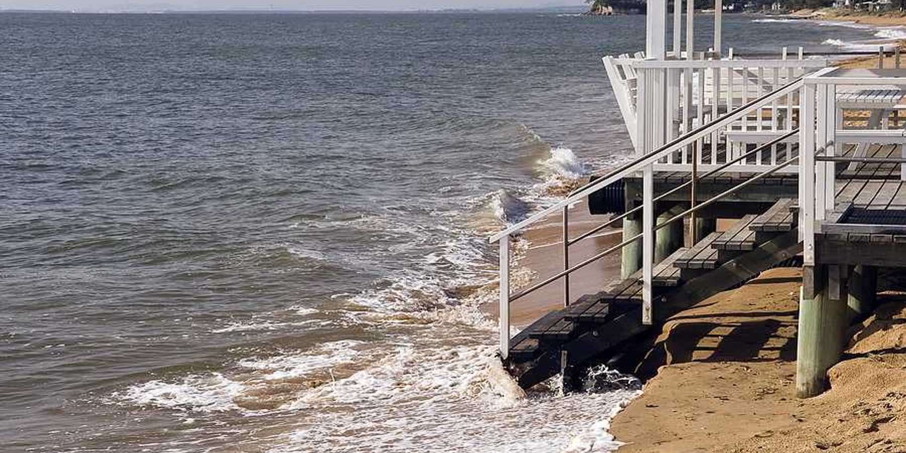 A home on a beach that is being inundated by sea water