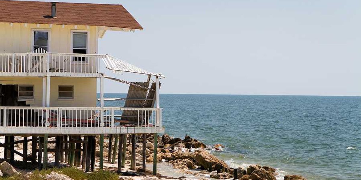 A home on stilts on the edge of an encroaching ocean