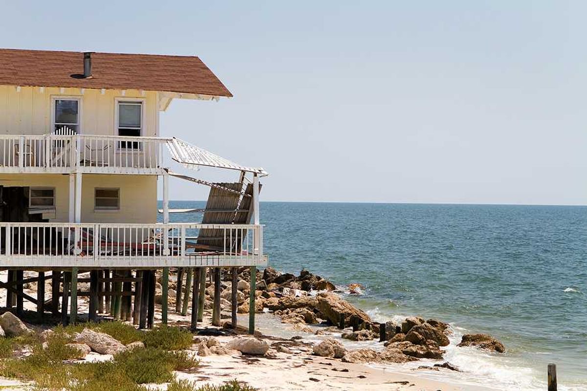 A home on stilts on the edge of an encroaching ocean