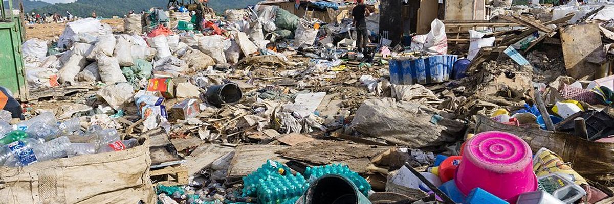 A landfill with piles of plastic waste being collected.