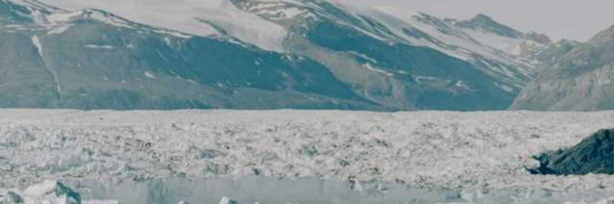 A large glacier with mountains in the background