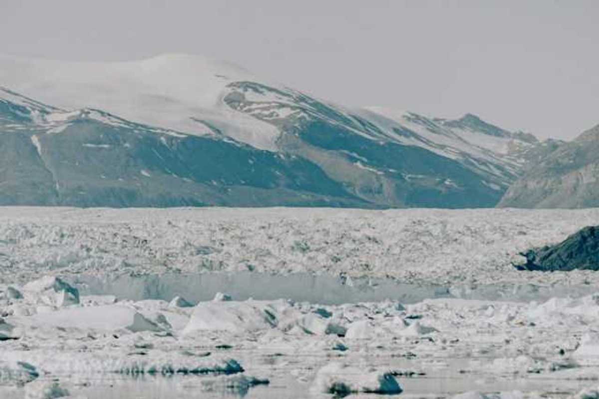 A large glacier with mountains in the background