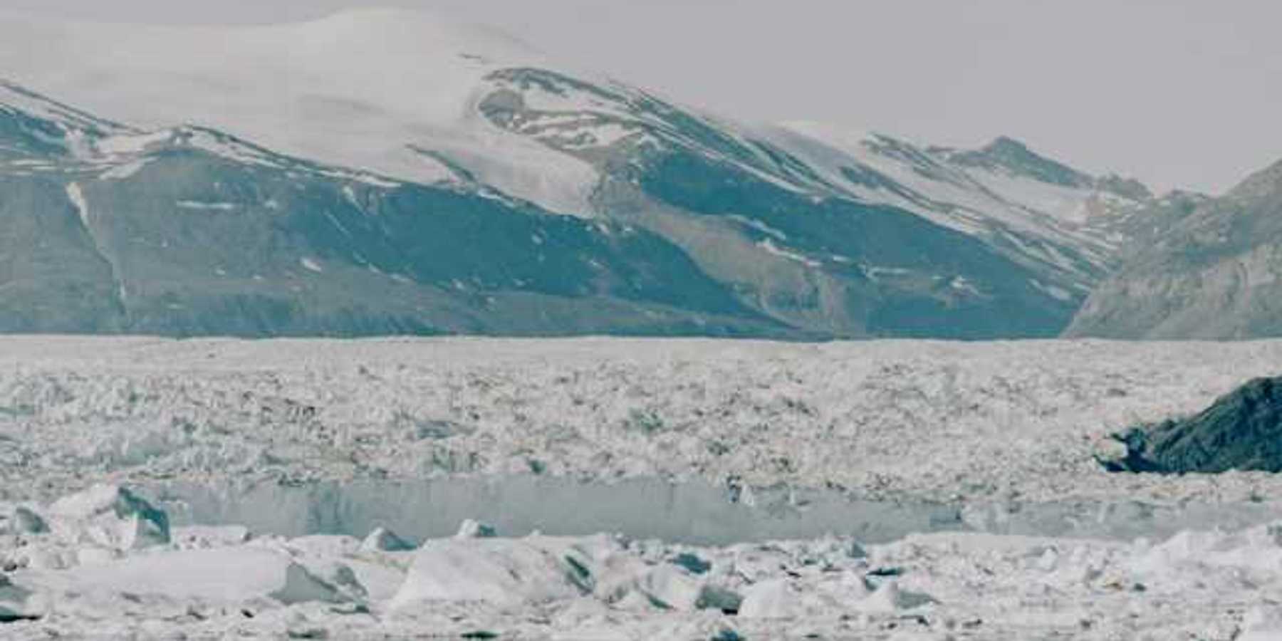 A large glacier with mountains in the background