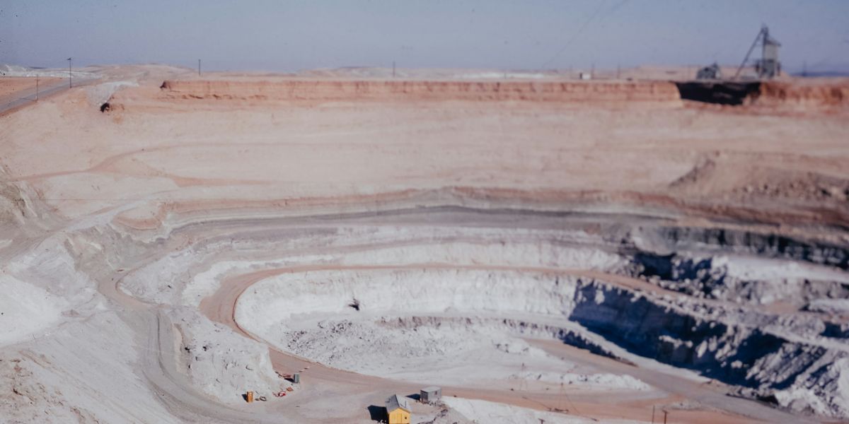 a large open pit filled with dirt and mining equipment.