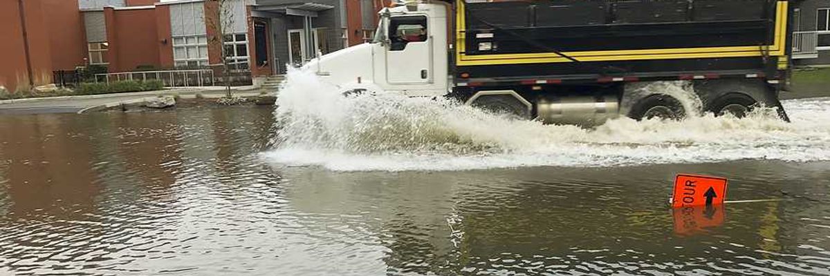 A large truck driving through a flooded street
