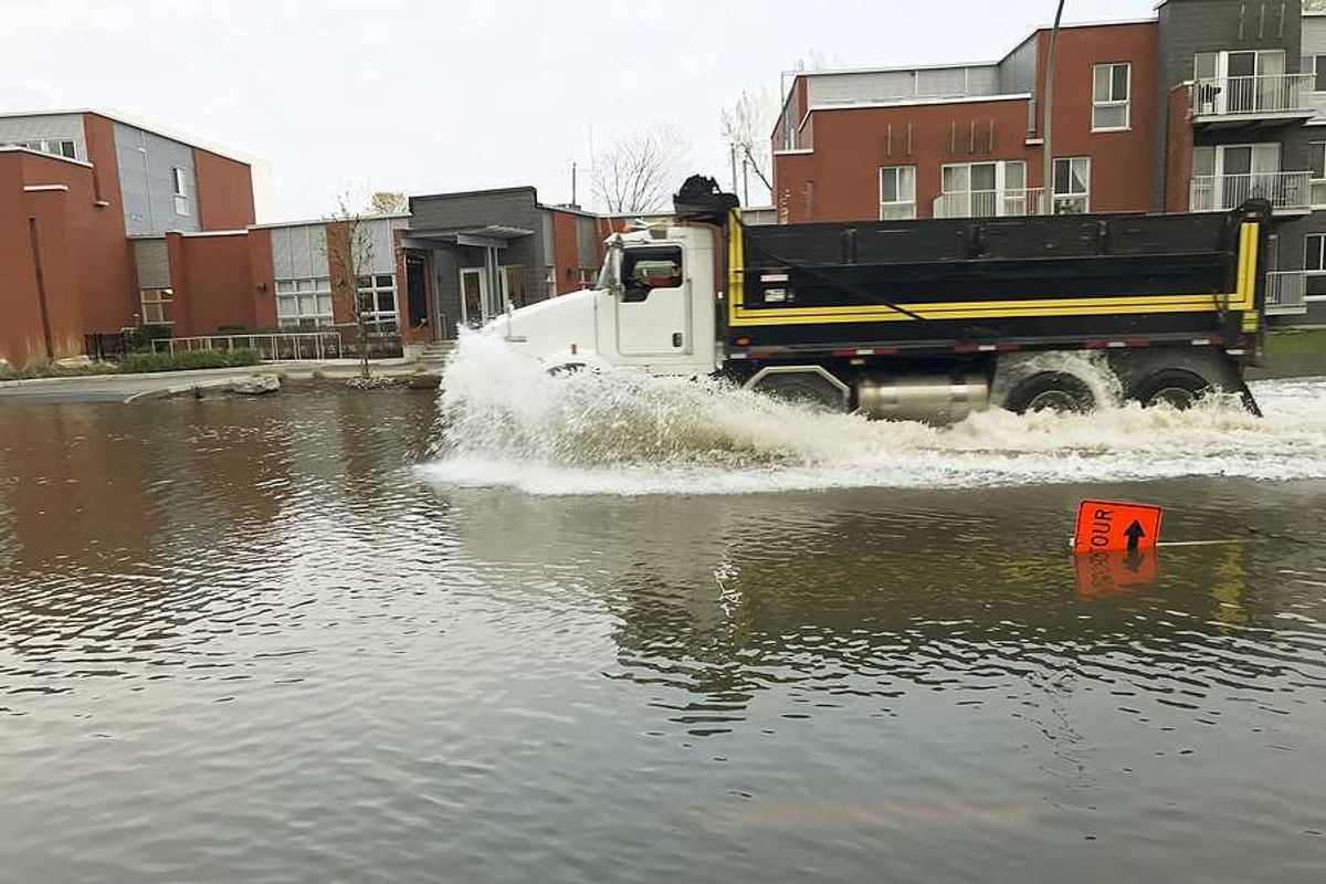 A large truck driving through a flooded street