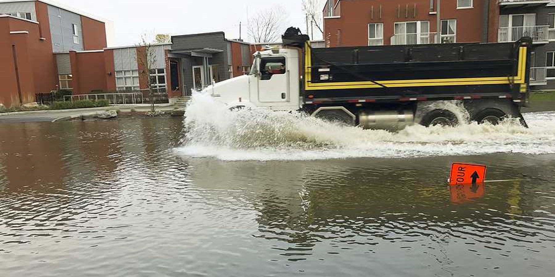 A large truck driving through a flooded street