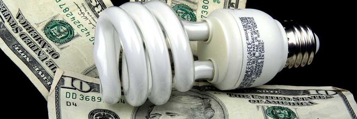 A lightbulb sitting on top of U.S. bills