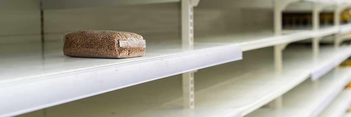 A lone package of grain on otherwise empty supermarket shelves