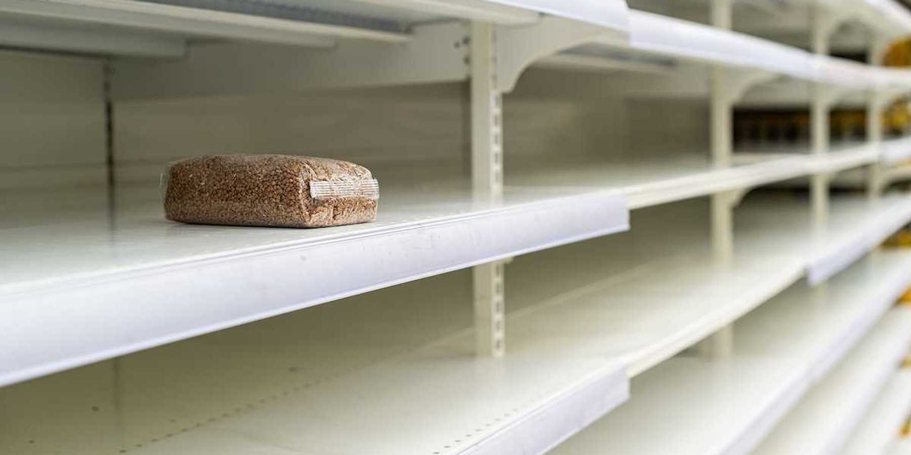 A lone package of grain on otherwise empty supermarket shelves